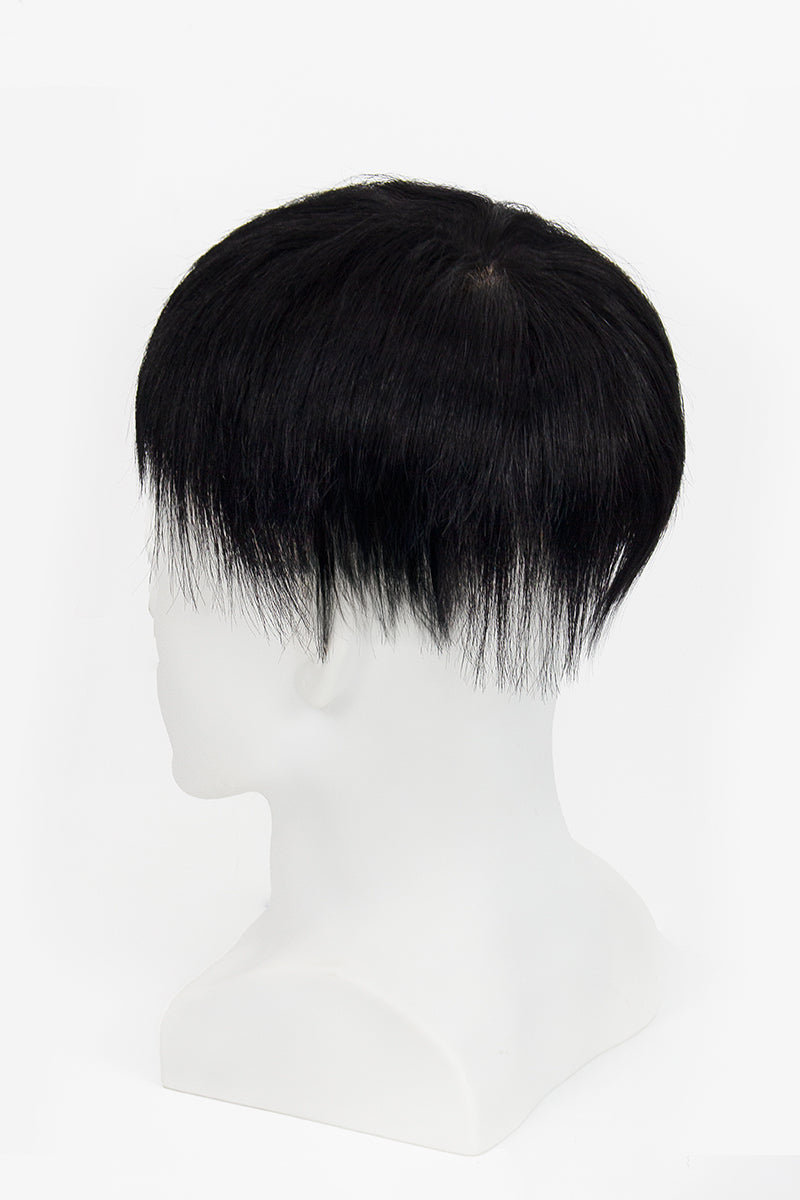 Black hair toupee on a mannequin head against a white background