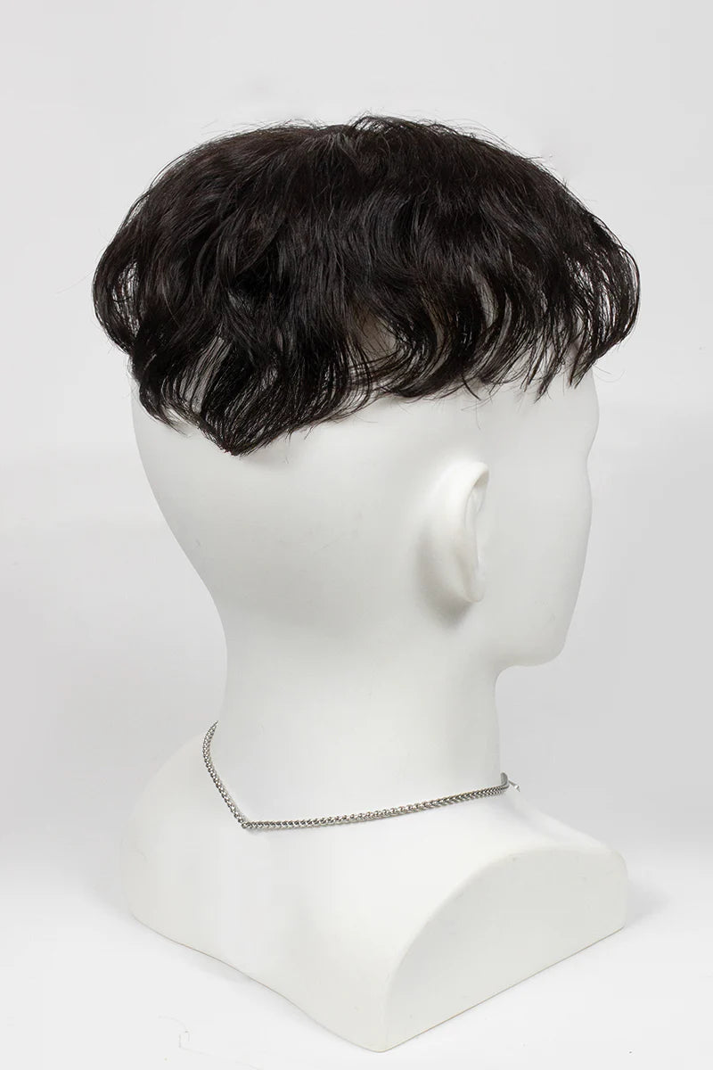 Man with styled hair and beard wearing a black turtleneck against a white background