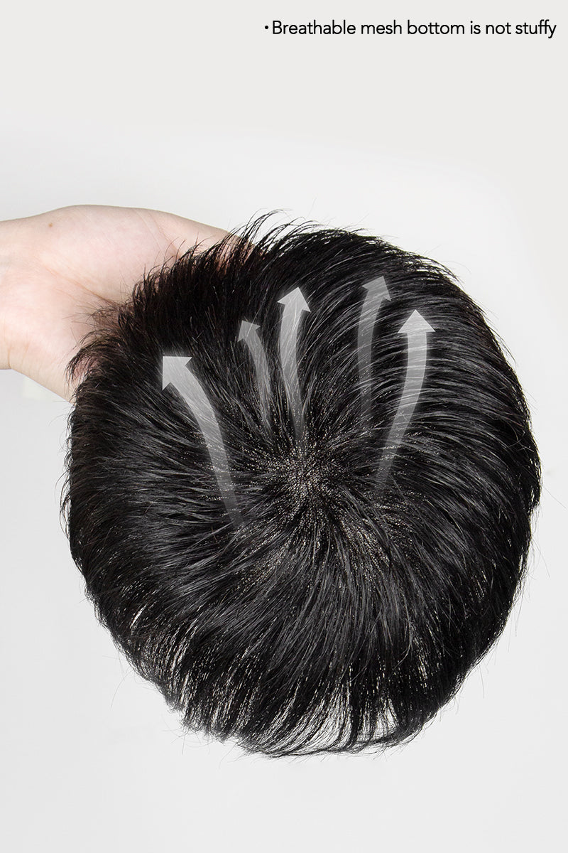 Black hairpiece held by a hand on a white background