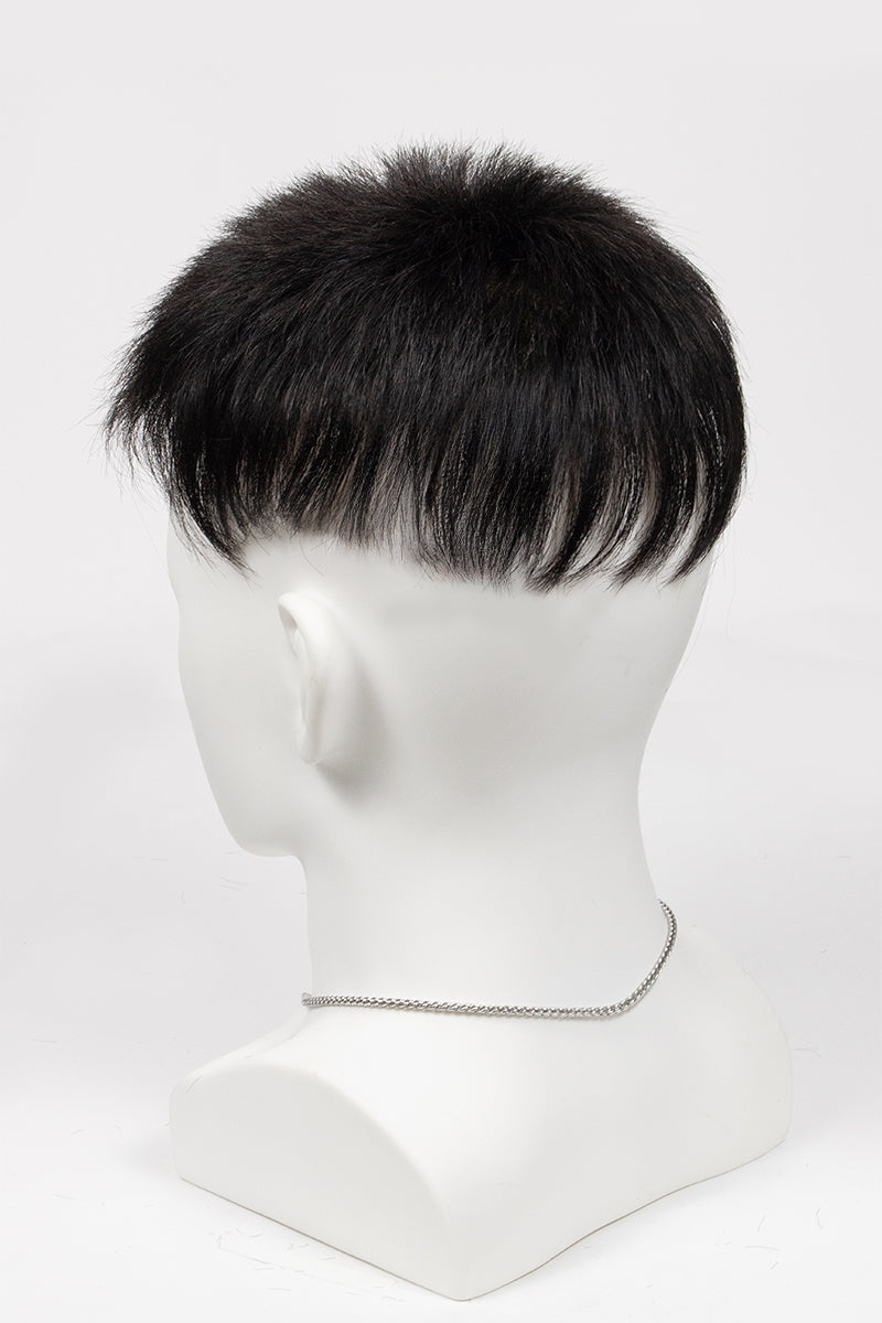 Black hairpiece on a mannequin head against a white background