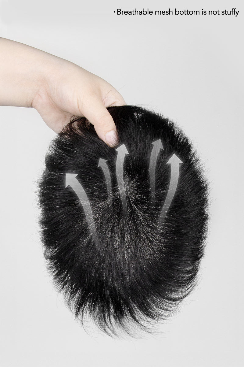 Black hairpiece held by a hand on a light gray background