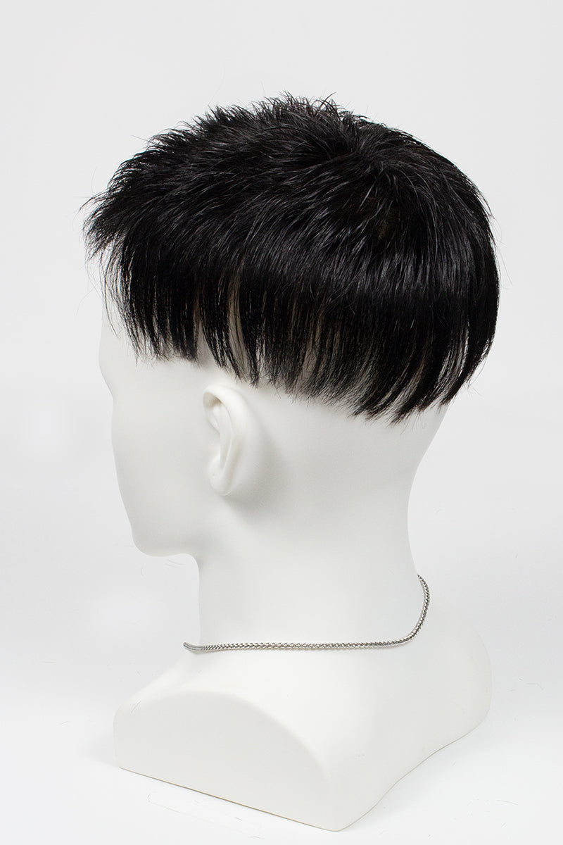 Black wig on a mannequin head against a white background