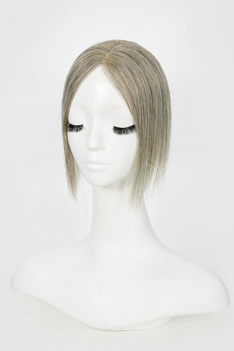 Mannequin head with a light brown grey topper on a white background