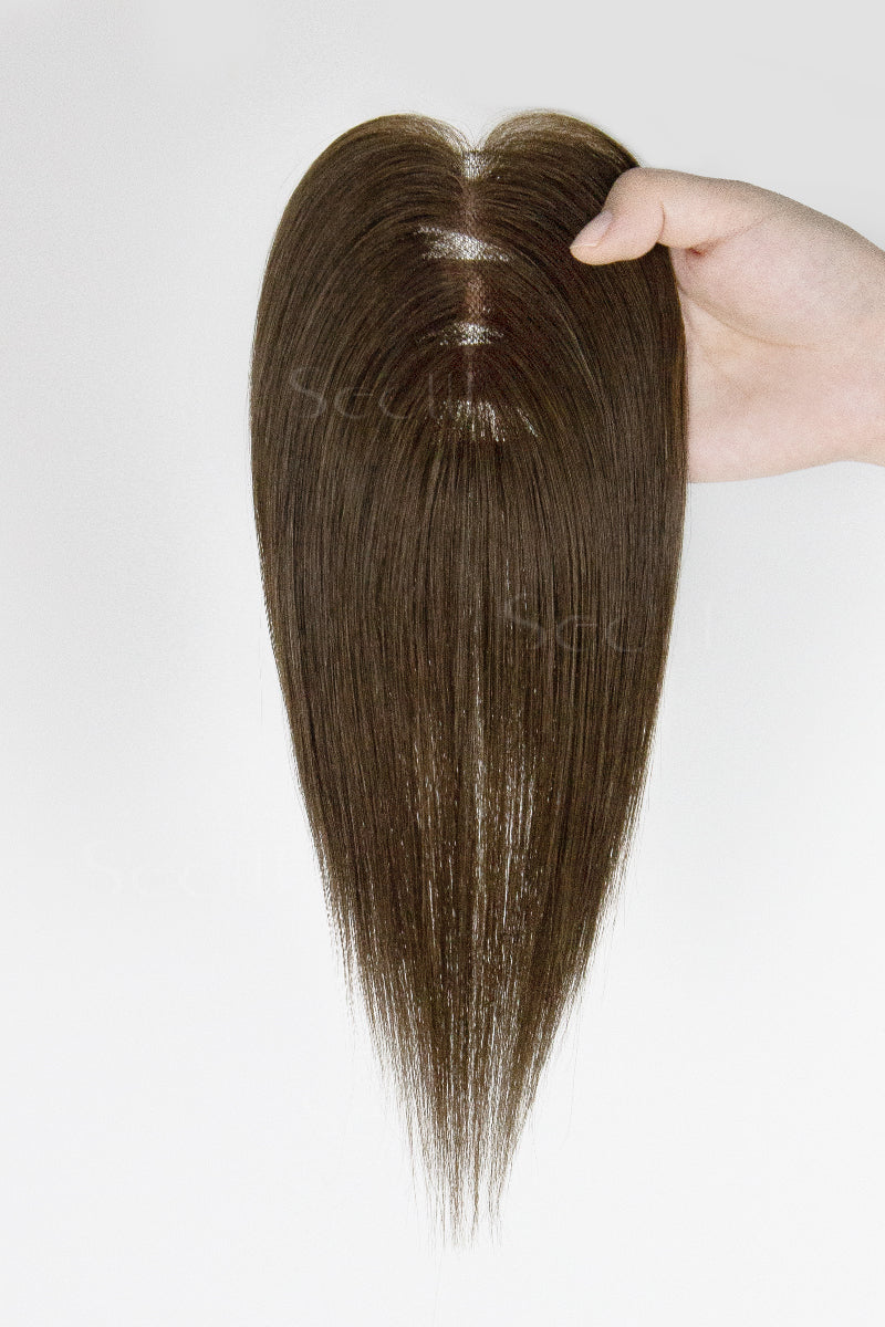 Mona Handmade Human Hair Topper Chocolate Brown #3 held by a hand on a white background