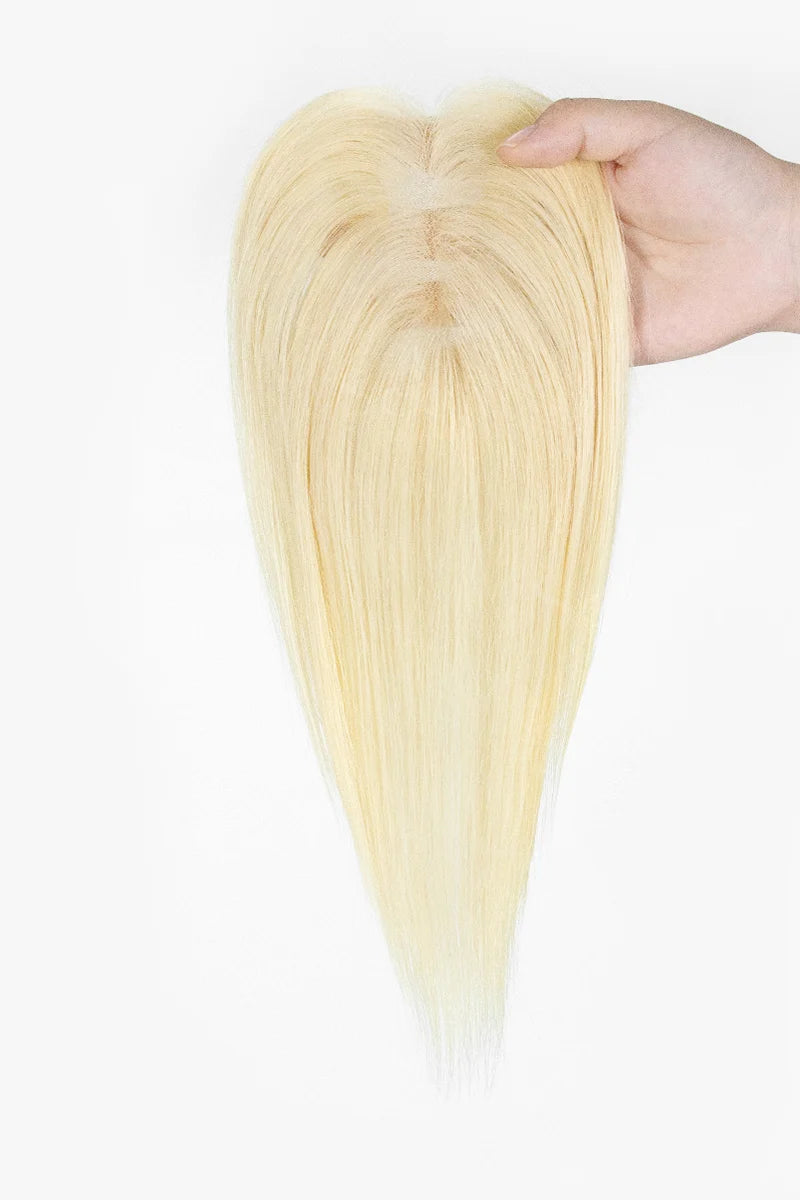 Mona Handmade Human Hair Topper Platinum Blonde #60 held by a hand against a white background