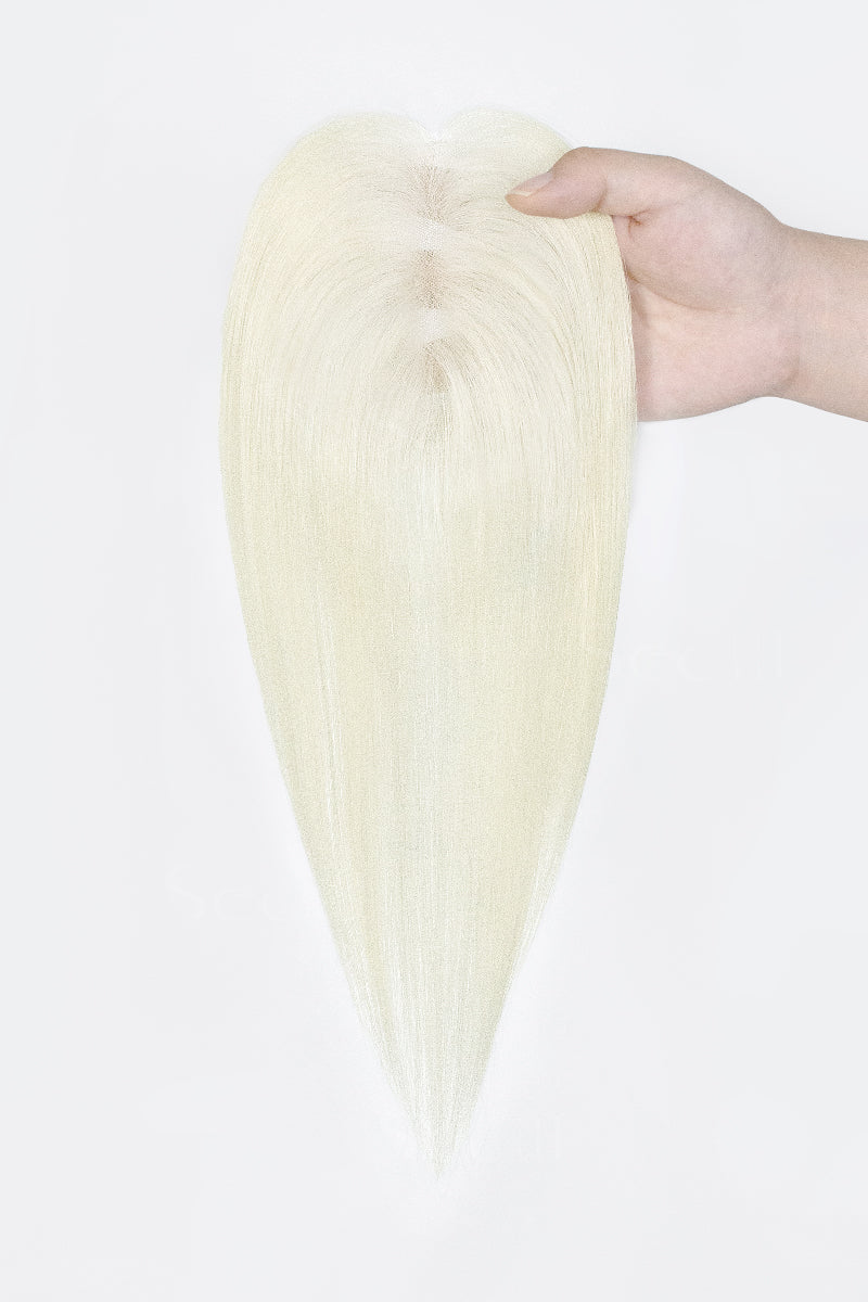 A long, straight, pointed blonde hair extension or wig piece held by a hand against a plain white background.
