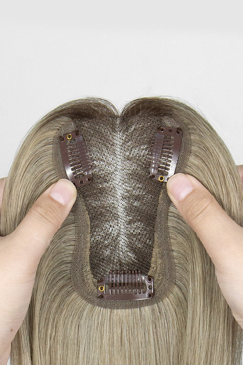 Mona Handmade Human Hair Topper Ombre Dark Root to Blonde #T2/M616 with clips held by a hand on a white background
